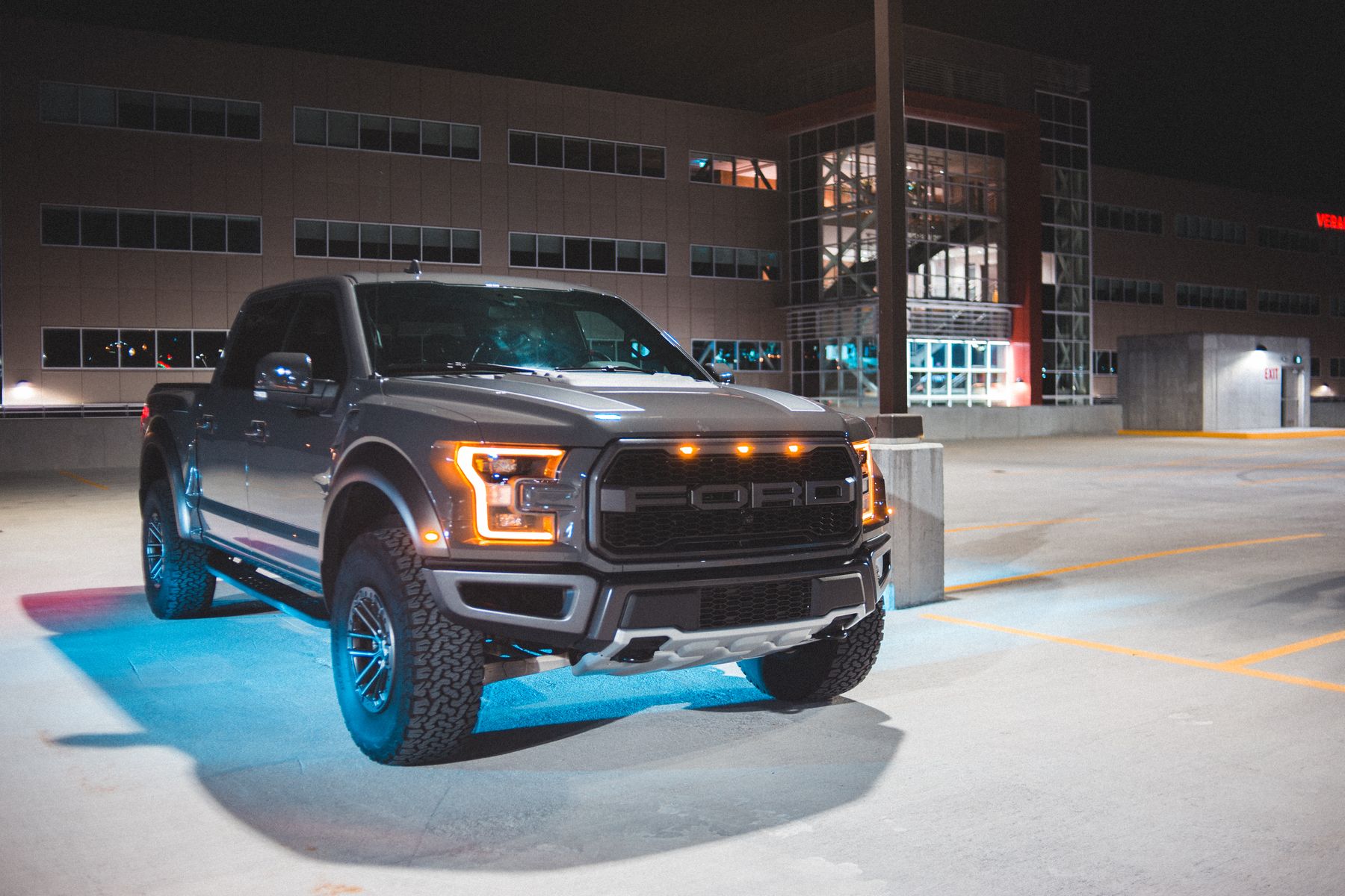 Gray pickup truck with lights on in a city parking area
